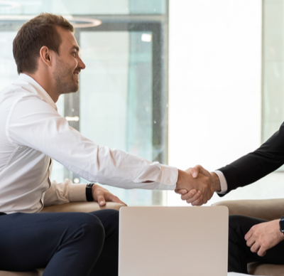 Horizontal view of a European and an Arabian business men in formal wear accomplish meeting shaking hands, HR manager greeting applicant before job interview process concept