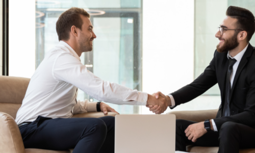Horizontal view of a European and an Arabian business men in formal wear accomplish meeting shaking hands, HR manager greeting applicant before job interview process concept