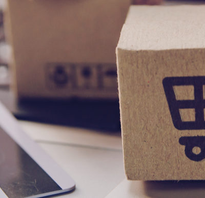 Online shopping - Paper cartons or parcel with a shopping cart logo and credit card on a laptop keyboard. Shopping service on The online web and offers home delivery.